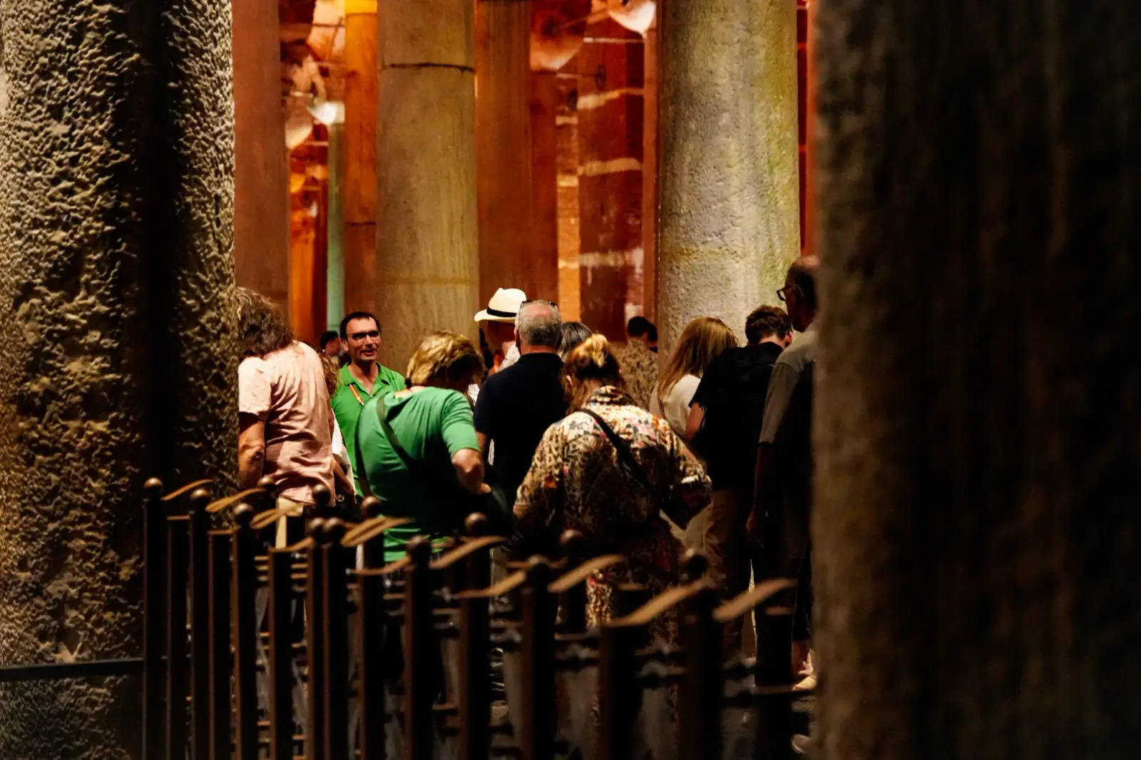 Illuminated wooden walkway over the water among marble columns inside the Basilica Cistern